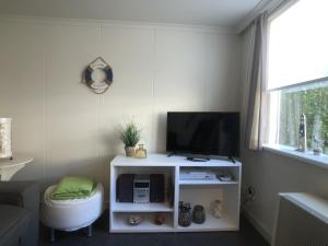 a living room with a television on a white cabinet at Egelantierlaan 21a in Cadzand