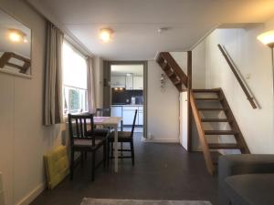 a room with a staircase and a table and a kitchen at Egelantierlaan 21a in Cadzand