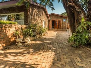 a brick house with a brick driveway at Lesedi Guesthouse Middleburg in Middelburg