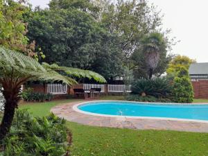 a swimming pool in a yard with a table at Lesedi Guesthouse Middleburg in Middelburg
