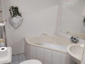 a bathroom with a tub and a toilet and a sink at Lesedi Guesthouse Middleburg in Middelburg