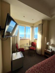a hotel room with a television and a table and chairs at Hotel Guerrero in Mar del Plata