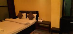 a small bedroom with a bed and a night stand at Ambience House in Pātan