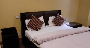 a bedroom with a bed with two pillows on it at Ambience House in Pātan