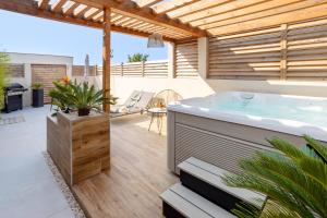een hot tub op de patio van een huis bij L'entre deux-suite romantique - jacuzzi privatif in Le Somail