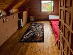 Habitación con cama y alfombra en el suelo de madera. en Anja rent house en Žabljak