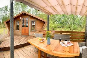 a wooden deck with a table and a cabin at Wooden tiny house Glamping cabin with hot tub 1 in Tuxford