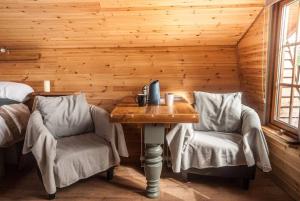 a wooden room with a table and two chairs at Wooden tiny house Glamping cabin with hot tub 1 in Tuxford