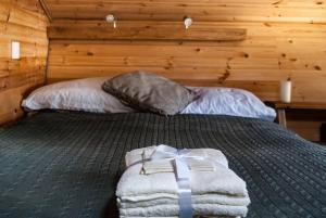a bedroom with a bed with a wooden wall at Wooden tiny house Glamping cabin with hot tub 1 in Tuxford