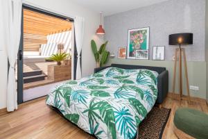 een slaapkamer met een bed met een groene en witte deken bij L'entre deux-suite romantique - jacuzzi privatif in Le Somail