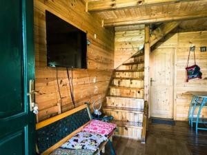 una habitación con banco y TV en una cabina en Anja rent house en Žabljak