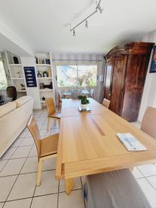 comedor y sala de estar con mesa de madera en Villa les mouettes, au bord de la mer. en Saint-Malo