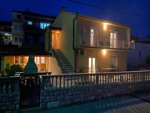 een huis met een balkon en een hek 's nachts bij Lana 1 in Senj