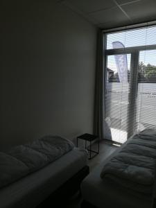 a bedroom with two beds and a large window at Nuvola ULTIMO Resort in Zottegem