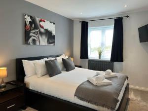 a bedroom with a large white bed with a window at Three Bed Townhouse with Parking in Telford