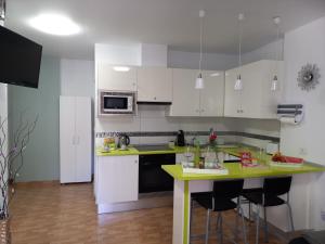 une cuisine avec des placards blancs et un comptoir jaune dans l'établissement Apartamento mesas del mar. Los sueños, à Tacoronte
