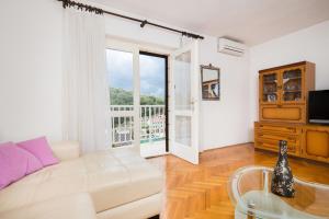 a living room with a white couch and a window at Apartments Maria in Povlja