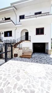 une maison blanche avec un sol en pierre et des escaliers dans l'établissement La Perla Nascosta, à Belvedere Marittimo