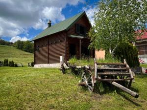 una cabaña de madera con un banco delante en Anja rent house en Žabljak