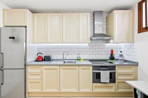 Una cocina con gabinetes de madera y un refrigerador blanco. en Duplex Ocean View Apartment in Neptuno, en Puerto de Santiago