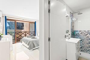 ein Bad mit einer Dusche und ein Schlafzimmer mit einem Bett in der Unterkunft Duplex Ocean View Apartment in Neptuno in Puerto de Santiago