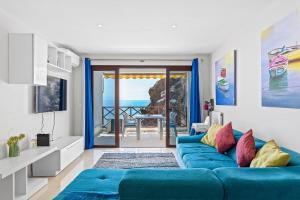 a living room with a blue couch and a view of the ocean at Duplex Ocean View Apartment in Neptuno in Puerto de Santiago