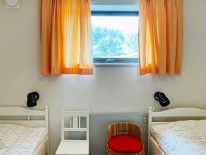 um quarto com duas camas e uma janela com cortinas laranja em Holiday home UDDEVALLA XXXVI em Uddevalla
