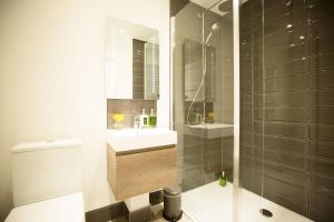 a bathroom with a sink and a toilet and a mirror at Tomdhu Lodge - Seasgair Lodges in Boat of Garten +8 photos