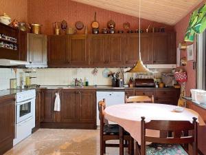 uma cozinha com armários de madeira e uma mesa em Holiday home UDDEVALLA XXXVI em Uddevalla