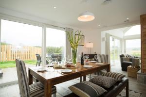 a dining room with a wooden table and chairs at Tomdhu Lodge - Seasgair Lodges in Boat of Garten