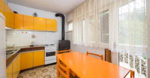 a kitchen with orange cabinets and a orange table at Apartments Maria in Povlja