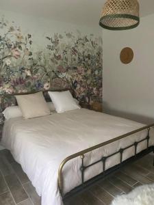 1 dormitorio con 1 cama y papel pintado con motivos florales en Zénitude et proximité, en Billère