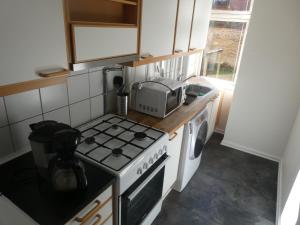 eine Küche mit einem Herd und einer Mikrowelle in der Unterkunft Østerbro Apartments 928 in Kopenhagen