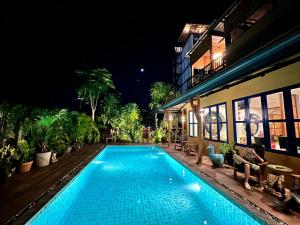 una piscina di fronte a un edificio di notte di The Luna a Nai Yang Beach