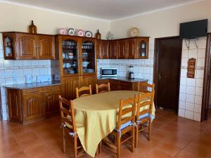 a kitchen with a table and chairs in a room at A Casa do Comandante in Lagoa