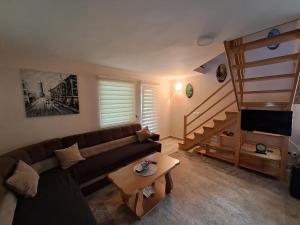 a living room with a couch and a staircase at Vikendica Pored Drine in Crvica