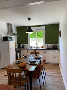 ブレシュイールにあるLe Cinquièmeのキッチン(テーブル、椅子付)、緑の壁のキッチン