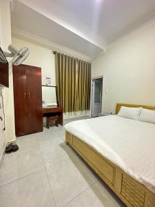 a bedroom with a large bed and a desk at Guesthouse Thắng Linh in Da Lat