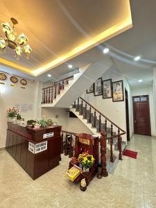a lobby with a staircase and a counter with flowers at Guesthouse Thắng Linh in Da Lat