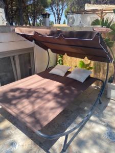 een overdekt bed met 2 kussens op een patio bij Casa Rural Los Pepe Sancti Petri in Chiclana de la Frontera