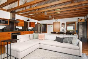 a living room with a white couch and a kitchen at Wild Run River House in Nehalem