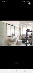 a bathroom with a sink and a toilet and a mirror at Room for rent in Roma Conca d'oro near subway line b in Rome