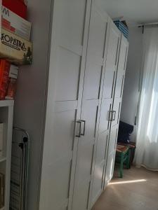 a row of white cabinets in a room at Room for rent in Roma Conca d'oro near subway line b in Rome