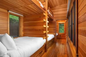 a bedroom in a log cabin with a bed at Wild Run River House in Nehalem