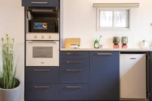 una cucina con armadi blu e stufa bianca di Wonderful at central - Bahai gardens - Ben gurion a Haifa Altre 7 foto