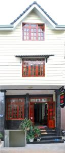 a white building with red doors and windows at Guesthouse Thắng Linh in Da Lat