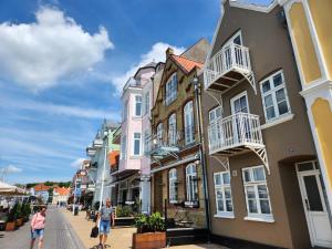 two people walking down a street in front of houses at Harbour Walk in Sønderborg