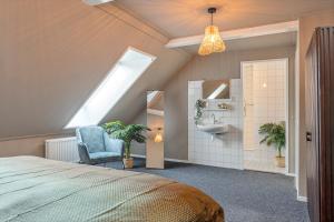 ein Schlafzimmer mit einem Bett, einem Waschbecken und einem Dachfenster in der Unterkunft Enschede83 in Enschede