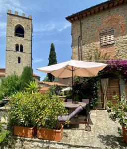 a table with an umbrella in front of a building at La Magione dei Todaro in Borgo a Buggiano