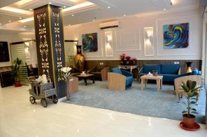 a lobby with a waiting room with blue couches and tables at فندق فربيون ابها - Ferbion Hotel Abha in Abha